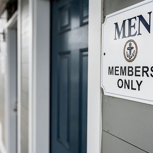 A sign on a gray building reads 