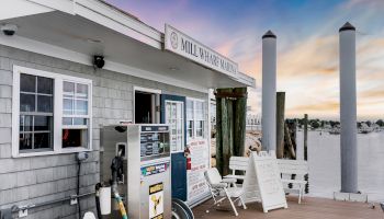 The image shows a dockside gas station and office with a sign 